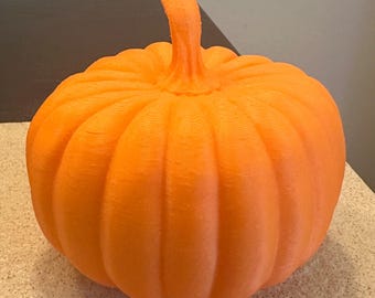 May include: A bright orange pumpkin with a textured surface and a stem. The pumpkin is a classic autumn decoration, perfect for fall displays and Halloween.