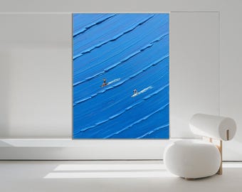 Op de afbeelding: Een rechthoekig schilderij op canvas met dikke, getextureerde blauwe olieverfstreken die oceaangolven voorstellen. Twee kleine figuren op surfplanken zijn in het midden geplaatst en vormen een contrast met het diepblauwe oppervlak. De tekst "Wonders Wendy Art" is zichtbaar in de rechterbenedenhoek.