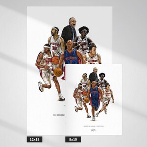 May include: A white art print featuring a detailed illustration of the 2003-2004 Detroit Pistons basketball team, including players in white and blue uniforms, a coach, and basketballs, with the text 2003-2004 NBA CHAMPIONS / DETROIT PISTONS.