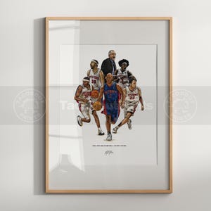 May include: A framed art print featuring a group of basketball players in white and blue Detroit Pistons uniforms, with a coach in a suit. The text reads 2003-2004 NBA CHAMPIONS DETROIT PISTONS. The players are shown in action with basketballs.