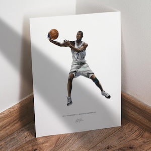 May include: A print featuring a basketball player in a white and green uniform, holding a basketball. The player is in mid-air, with the number 21 visible on the jersey. The print includes text at the bottom: "KEV # KEVIN GARNETT // MINNESOTA TIMBERWOLVES."