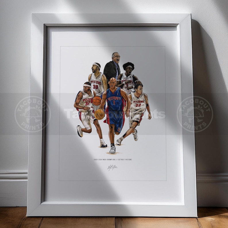 May include: A framed art print featuring a detailed illustration of the 2003-2004 Detroit Pistons basketball team, including players in white and blue uniforms, a coach, and basketballs, with the text 2003-2004 NBA CHAMPIONS // DETROIT PISTONS.