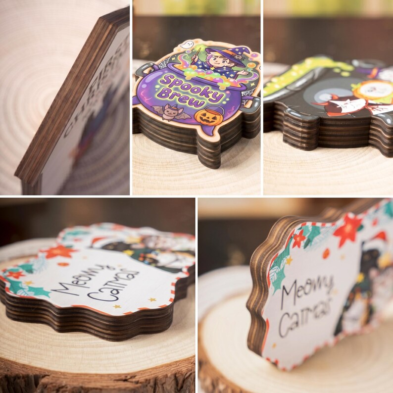 May include: Wooden coasters with decorative designs. One coaster features a witch in a cauldron with the text "Spooky Brew". Another coaster has the text "Meowy Catmas" with a cat illustration. The coasters have a dark brown edge.