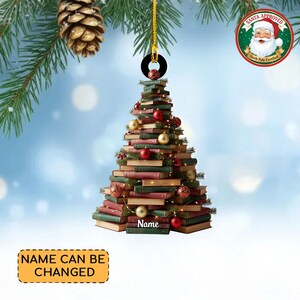 Puede incluir: Adorno navideño con forma de árbol hecho de libros. El adorno está decorado con bolas rojas y doradas. El texto "Name" es visible. El texto "NAME CAN BE CHANGED" también es visible.