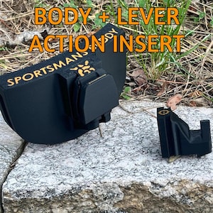 May include: Black "Sportsman's" lever action insert and body. The text "BODY + LEVER ACTION INSERT" is in orange. The body has a curved design with a rectangular insert. The insert is separate from the body.