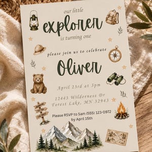 Op de afbeelding: Een rechthoekige uitnodigingskaart met de tekst our little explorer is turning one Oliver April 23rd at 3pm 12443 Wilderness Dr Forest Lake, MN 32943 Please RSVP to Sam (555) 123-0972 by April 15th en illustraties van een lantaarn, rugzak, hoed, kompas, beer, verrekijker, wegwijzer, kampvuur, bergen, bomen en een kaart.