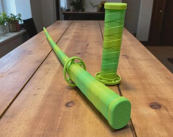 May include: A bright lime green sword with a textured handle and a matching separate handle piece. The sword features a circular guard and a long, tapered blade. The handle has a wrapped appearance, and the pommel displays embossed lettering.