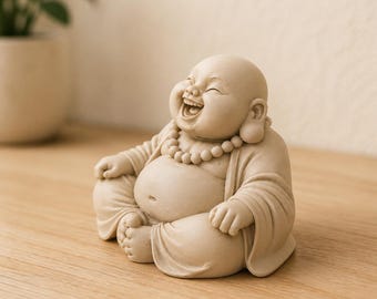 May include: A beige, matte-finish figurine of a laughing Buddha sitting in a cross-legged position. The figure features a round belly, a wide open-mouthed smile, and a beaded necklace draped around the neck, all rendered in a smooth, solid material.