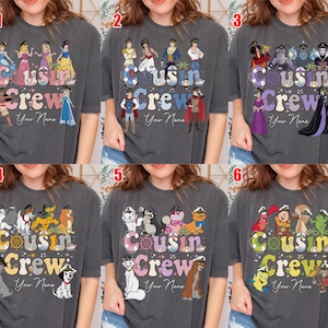 May include: Dark gray t-shirts with the text "Cousin Crew" and "Your Name" are displayed. Each shirt features a different graphic of cartoon characters, including princesses, princes, villains, and various animal characters.