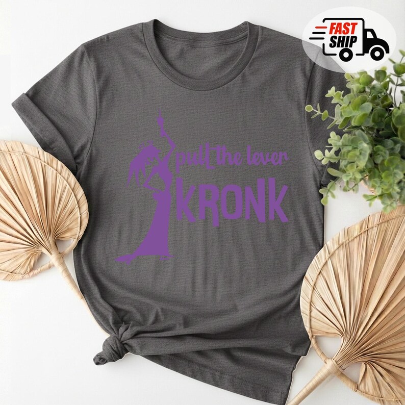 May include: Dark gray t-shirt with a purple graphic of a character and the text "pull the lever KRONK". The shirt is folded and knotted at the bottom. A Fast Ship logo is in the upper right corner.
