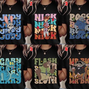 May include: Black t-shirts featuring characters from the animated movie Zootopia. Each shirt displays a different character's name and image: Judy Hopps, Nick Wilde, Chief Bogo, Gary, Flash, and Mr. Big. The designs use various colors and fonts.