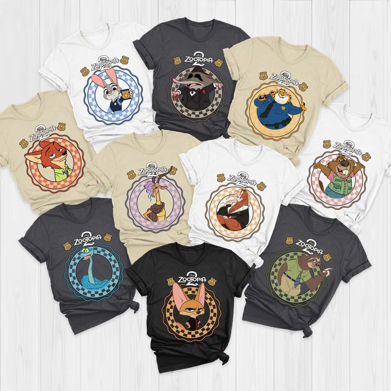 K&ouml;nnte beinhalten: Eine Sammlung kurz&auml;rmeliger T-Shirts in verschiedenen Farben, die jeweils einen anderen Charakter aus dem Animationsfilm "Zoomania" zeigen. Die Shirts haben ein kreisf&ouml;rmiges Design mit dem Logo des Films und Charakterillustrationen.