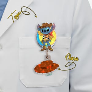 May include: A badge reel with a cartoon image of Stitch dressed as Woody from Toy Story. The badge reel has a brown cowboy hat charm and a clear plastic reel. The image is on a white lab coat.