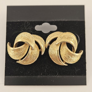 May include: A set of three ceramic mugs with a speckled, matte finish. The mugs are in shades of cream, light gray, and dark gray. Each mug has a simple, minimalist design and a rounded handle. The mugs are stacked on top of each other.