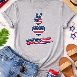 Woman styled outfit featuring kayaking shirt creek floating design on athletic heather Bella Canvas 3001 t shirt with denim shorts sandals and summer accessories flat lay