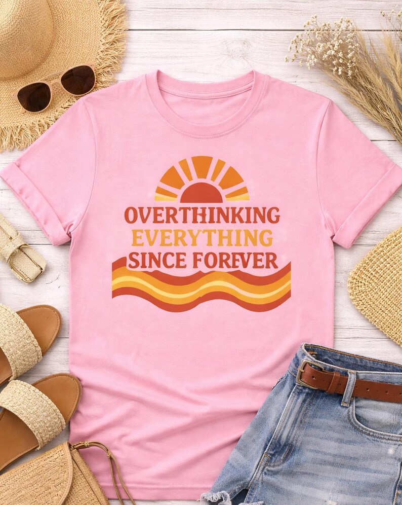 Flat lay showing pink funny overthinking graphic shirt with summer outfit aesthetic unisex t shirt