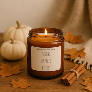 May include: A lit brown glass candle jar with a white label that reads "YOUR DESIGN HERE". Two small white pumpkins and fall leaves are in the background. Cinnamon sticks are tied together with twine.