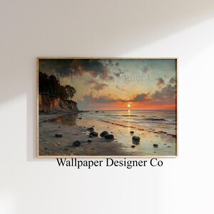 May include: A framed landscape print depicts a beach scene at sunset. The sky is filled with orange and gray clouds, and the sun is setting over the ocean. The beach has dark rocks and the text "Wallpaper Designer Co."