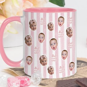 May include: A ceramic mug with a pink and white vertical striped pattern, featuring repeated photographic portraits of a baby wearing a pink bow and the repeating text Best nana ever in a cursive script, with a solid pink handle and interior.