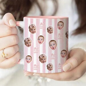 May include: A ceramic mug with a light pink and white vertical striped pattern. The mug features repeating circular photo cutouts of a baby wearing a pink bow, interspersed with the repeating cursive text "Best nana ever" in a light pink color.