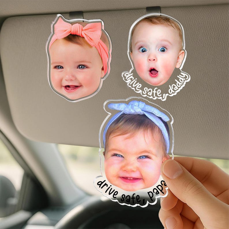 Puede incluir: Tres clips de acr&iacute;lico personalizados para visera de coche con retratos fotogr&aacute;ficos de beb&eacute;s. Un beb&eacute; lleva un lazo color melocot&oacute;n, otro tiene una expresi&oacute;n de sorpresa con el texto drive safe, daddy, y otro lleva una diadema azul con el texto drive safe, papa.