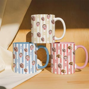 May include: Three ceramic mugs featuring vertical stripes and repeating photo prints of babies and dogs. The top mug is cream with white stripes, the bottom left is light blue, and the bottom right is pink. Each mug displays the text Best Mimi Ever.