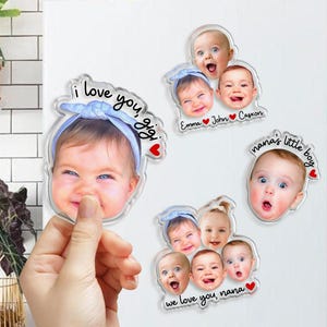 May include: Four custom acrylic photo magnets featuring portraits of infants. One magnet shows a baby in a blue headband with the text I love you, gigi. Another displays three babies with names Emma, John, and Casxon. A third shows one baby with nana's little boy text, and the fourth shows four babies with we love you, nana text.