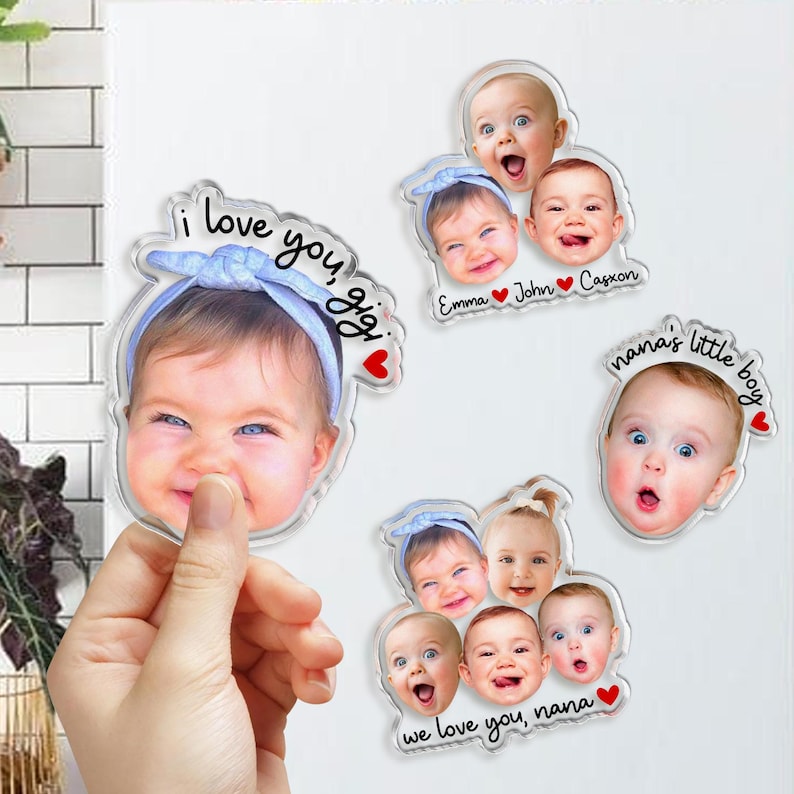 May include: Four custom acrylic photo magnets featuring portraits of infants. One magnet shows a baby in a blue headband with the text I love you, gigi. Another displays three babies with names Emma, John, and Casxon. A third shows one baby with nana's little boy text, and the fourth shows four babies with we love you, nana text.