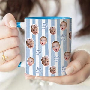 May include: A ceramic mug with a light blue and white vertical striped pattern. The mug features repeating circular portraits of a baby wearing a pink bow, interspersed with the handwritten-style blue text that reads Best mimi ever.