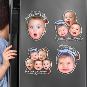 May include: Four custom acrylic photo magnets featuring baby portraits. One shows a baby with the text "nana's little boy" and a red heart. Another displays three babies labeled "Emma", "John", and "Casxon". A third shows three babies with "we love you, nana". The last shows one baby with "i love you, gig".
