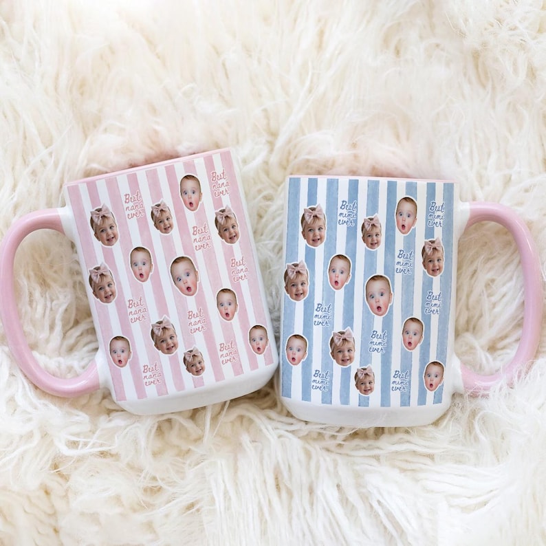 May include: Two ceramic mugs with pink handles. The left mug has pink vertical stripes and the text "Best nana ever" repeated with baby photos. The right mug has blue vertical stripes and the text "Best mimi ever" repeated with baby photos.