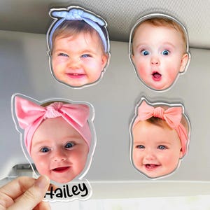Puede incluir: Cuatro imanes fotogr&aacute;ficos de acr&iacute;lico personalizados con rostros de beb&eacute;s. Un im&aacute;n muestra a un beb&eacute; con una diadema azul claro, otro con expresi&oacute;n de sorpresa, otro con una diadema rosa y el nombre Hailey, y otro con una diadema color melocot&oacute;n.