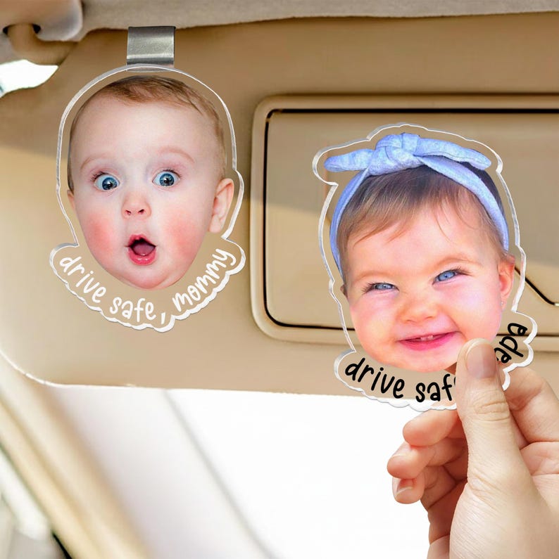 Puede incluir: Dos clips de acr&iacute;lico transparente para visera de coche con recortes de fotos personalizados de beb&eacute;s. Uno muestra a un beb&eacute; con expresi&oacute;n de sorpresa y el texto drive safe, mommy. El otro muestra a un beb&eacute; sonriente con una diadema azul y el texto drive safe, papa.
