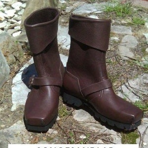 May include: A pair of brown leather boots with a fold-over cuff and buckle detail. The boots have a chunky heel and a rugged sole.