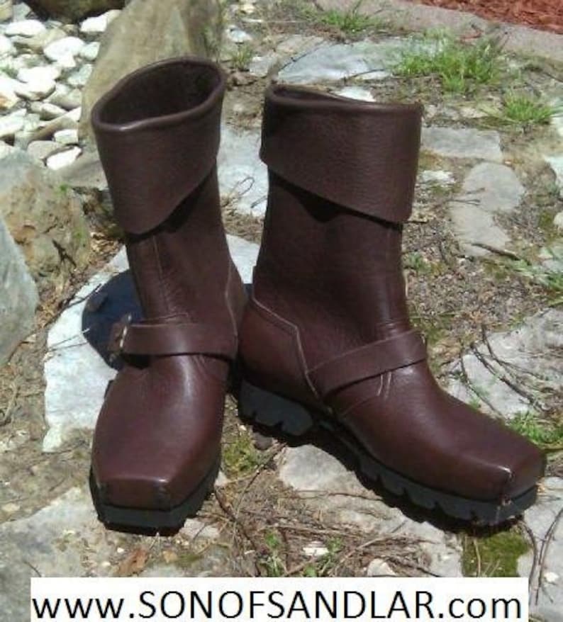 May include: A pair of brown leather boots with a fold-over cuff and buckle detail. The boots have a chunky heel and a rugged sole.