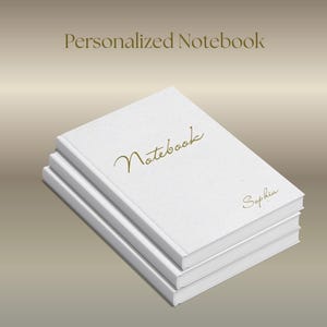 May include: A stack of three white notebooks. The top notebook has the word "Notebook" in gold script and the name "Sophia" in a smaller gold script. The text "Personalized Notebook" is at the top.