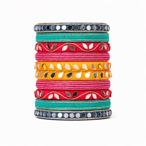 Puede incluir: Una pila de pulseras coloridas en tonos de turquesa, rojo, rosa y amarillo. Las pulseras están adornadas con detalles de espejo y patrones decorativos. Las pulseras están apiladas una encima de la otra, creando una exhibición vibrante y llamativa.