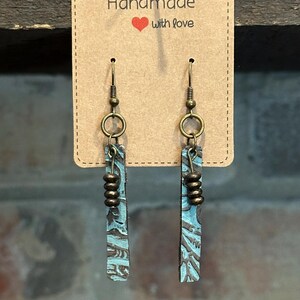 Turquoise textured leather earrings with beads.
