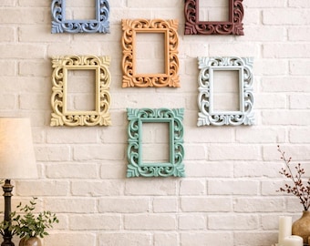 Può includere: Sei cornici rettangolari ornate in vari colori pastello sono montate su un muro di mattoni bianchi. Le cornici sono blu, pesca, rosso-marrone, giallo, verde e bianco. Le cornici presentano disegni intagliati dettagliati.