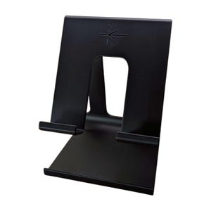 Pode incluir: Um suporte de metal preto com uma base retangular e uma parte traseira vertical. O suporte tem um recorte no centro e um pequeno símbolo de seta na parte superior. O suporte foi projetado para segurar um tablet ou telefone.