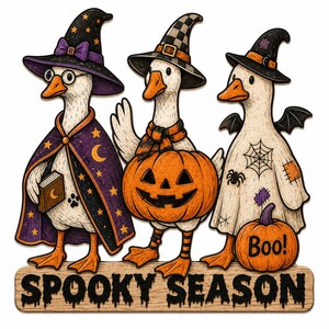May include: Three white geese dressed in Halloween costumes stand above a wooden sign that reads SPOOKY SEASON. The left goose wears a purple star-patterned cloak and hat, the center goose holds a jack-o'-lantern, and the right goose wears a ghost sheet.
