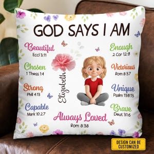 May include: White square pillow with floral and butterfly accents. Text reads "GOD SAYS I AM" with words like "Beautiful", "Chosen", and "Strong". A cartoon girl is in the center, with the name "Elizabeth".