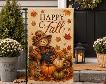 May include: A rectangular garden flag featuring the text Happy Fall in brown script. The design displays a scarecrow in blue overalls and a plaid shirt, two pumpkins, a rabbit, and a squirrel surrounded by orange and red autumn leaves.