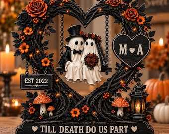 May include: A decorative figurine featuring two ghost figures in wedding attire sitting on a swing inside a heart-shaped frame. The frame is adorned with orange roses, black leaves, mushrooms, and a lantern. Text includes M A, EST 2022, and TILL DEATH DO US PART.