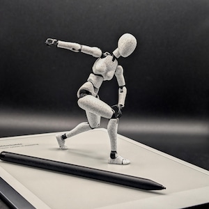 May include: A poseable artist's mannequin in a dynamic pose, with a black stylus resting on a digital tablet. The mannequin is light grey with black joints, set against a dark background. The tablet is white with a black border.