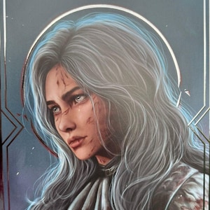 May include: A silver-bordered art print featuring a portrait of a woman with long, gray hair and a blue halo. The artwork has a dark background and the number "33" at the top. The woman's face shows signs of injury.