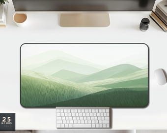 May include: A rectangular desk mat featuring a landscape design of rolling green hills and grassy fields. The color palette is soft, with shades of green and white. A keyboard and mouse are visible below the mat. The text "25 HOURS STUDIO" is in the lower left corner.