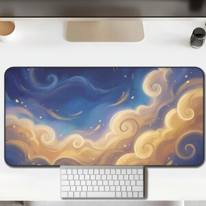 May include: A rectangular desk mat featuring a dreamy cloudscape design. The artwork showcases swirling, golden-yellow clouds against a deep blue sky, with subtle hints of light and stars. A white keyboard and mouse are visible.