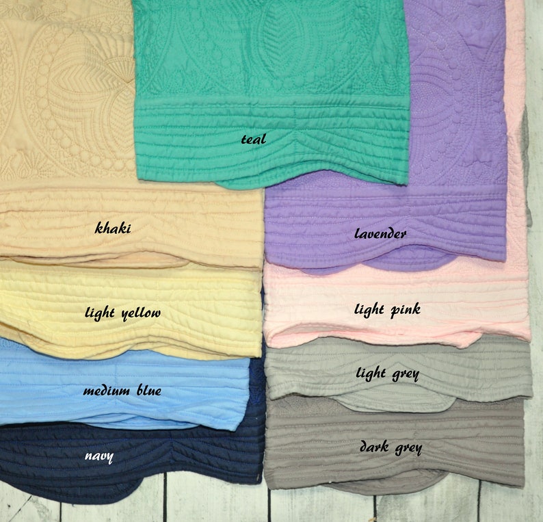 Puede incluir: Una colecci&oacute;n de diez muestras de tela acolchada con bordes festoneados y patrones circulares en relieve. Los colores est&aacute;n etiquetados como teal, khaki, lavender, light yellow, light pink, medium blue, light grey, navy y dark grey.