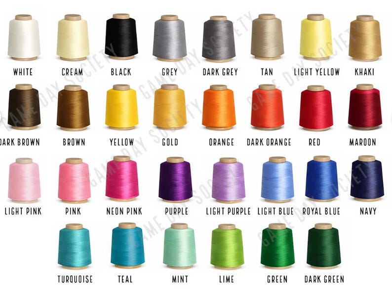 Puede incluir: Una colecci&oacute;n de treinta y dos carretes de hilo dispuestos en cuatro filas, con un amplio espectro de colores que incluye blanco, crema, negro, gris, beige, amarillo, caqui, marr&oacute;n, naranja, rojo, granate, rosa, morado, azul, verde y varios tonos.